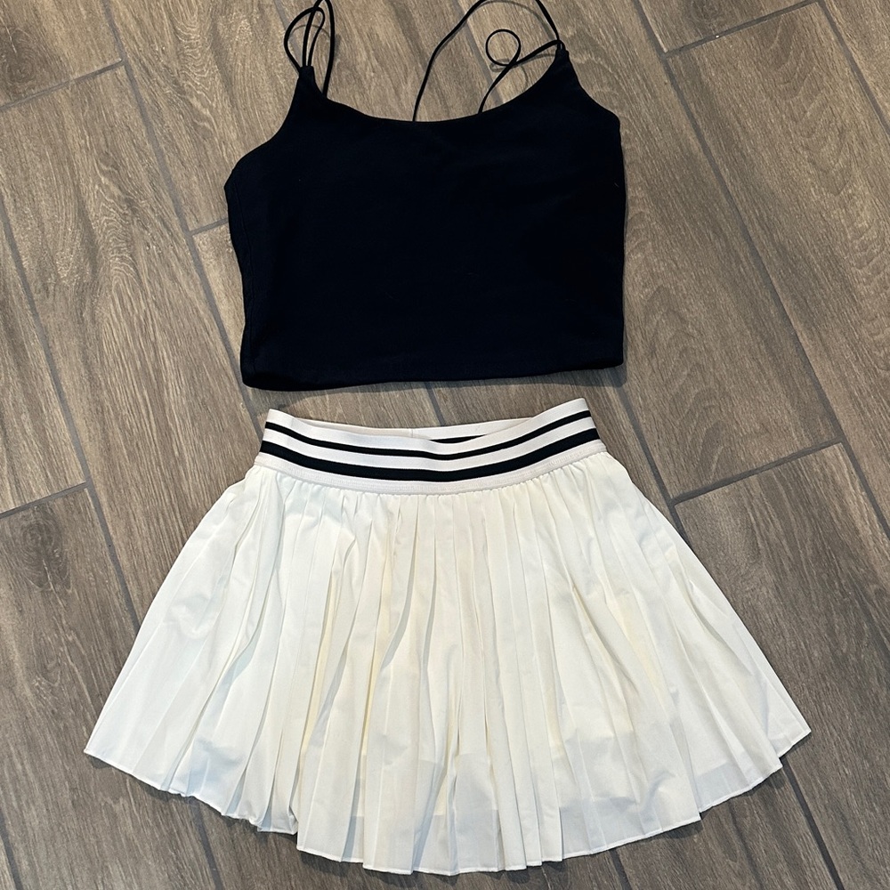 A & F cropped black fitted top. White pleated skirt with striped waistband. S